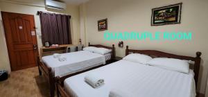 塔比拉兰日景旅游者之家旅馆的配有白色床单的客房内的两张床