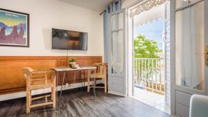 圣丹尼斯1A - Chambres et Appartements au calme - Centre St Denis - Barachois的客房设有桌子和带电视的阳台。