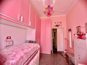 圣玛格丽塔-利古雷Notti magiche a Santa Margherita ligure的粉红色的卧室配有一张床和吊灯