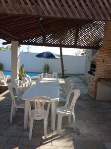 雅克南Casa de praia em Carapibus的庭院里配有桌椅和遮阳伞