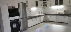非斯APPARTEMENTS NIA CONFORT, Plein centre ville, avec TERRASSE的厨房配有白色橱柜、洗衣机和烘干机