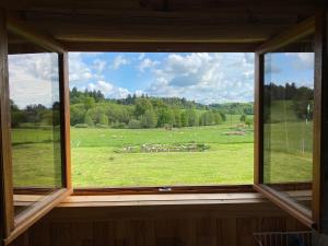 Roulottes des terres de la chouette的享有绵羊田野景致的窗户
