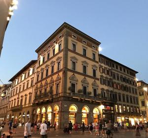佛罗伦萨Palazzo Gamba Apartments al Duomo的一座大型建筑,前面的人在步行