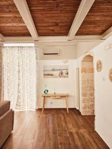莫尔费塔Acacia Apartment的客厅设有木制天花板和桌子