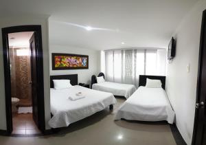 皮塔利托Hotel Andinos Plaza Pitalito的酒店客房,设有两张床和镜子