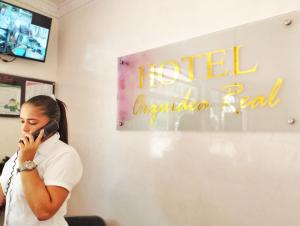 巴耶杜帕尔Hotel Orquídea Real的一个女人在屋子里用手机说话