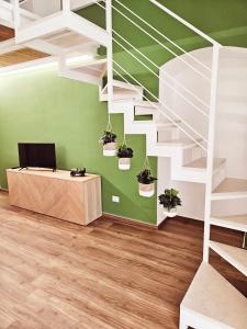 莫尔费塔Acacia Apartment的一间拥有绿色墙壁和白色楼梯的客房