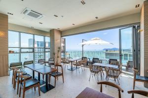 釜山ELBON the stay Haeundae beach的一间带桌椅的海景餐厅