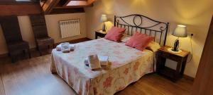 Argamé阿加玛乡村公寓酒店的卧室配有一张带粉红色枕头的大床