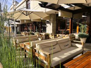 米娜克拉韦罗Coronado Hotel的餐厅配有沙发、桌子和遮阳伞