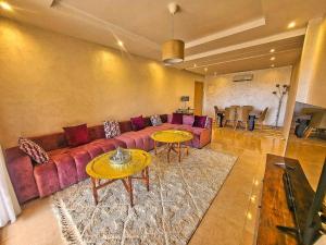 马拉喀什appartement moderne au style beldi résidence au centre de Marrakech avec piscine的客厅配有沙发和2张桌子