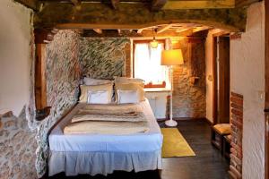 利亚内斯El nido de la golondrina的卧室配有一张石墙床