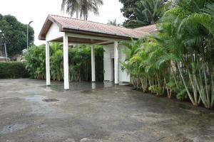 丘达德马拉波Industria Villa的停车场内一个棕榈树白色凉亭