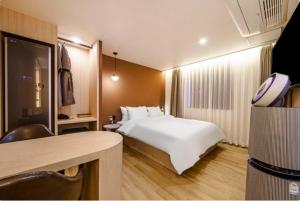 釜山Brown Dot Hotel Yeonsan的配有一张床和一张书桌的酒店客房