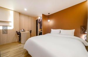 釜山Brown Dot Hotel Yeonsan的卧室配有一张白色大床和一张书桌