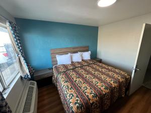 乔普林Super 7 inn的一间卧室配有一张蓝色墙壁的床