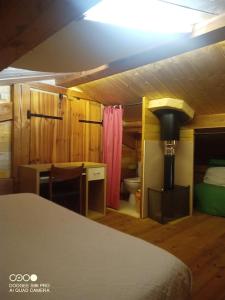 RoguesLa Laouze - Small wooden house Eco-Low-tech的一间带一张床和一张书桌的卧室以及一间浴室。