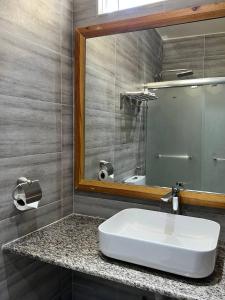 图鲁斯杜Aasna Inn的浴室设有白色水槽和镜子