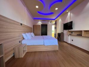 图鲁斯杜Aasna Inn的一间卧室配有一张蓝色天花板的床