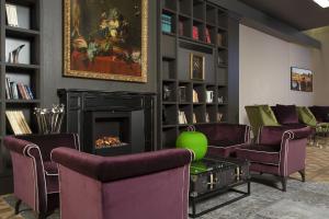 佛罗伦萨斯帕戴酒店的客厅配有紫色椅子和壁炉