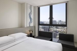 首尔首尔费尔菲尔德客栈酒店的一间卧室配有一张床、两把椅子和一个窗户
