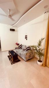 勒克瑙Atulyam Stays Sushant Golf City的带沙发和植物的客厅