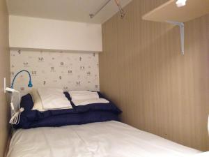 北九州小仓福冈小亚洲旅舍的墙上的小床