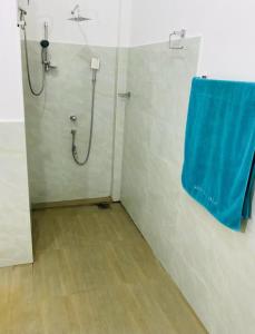 本托塔Ayurveda Suwetha Villa的浴室设有淋浴,墙上有蓝色毛巾