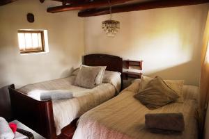 PescaPosada el portal de la Loma的一间卧室配有两张床和吊灯。