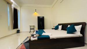 勒克瑙Atulyam Stays Sushant Golf City的一间卧室配有一张带蓝色和白色枕头的床