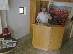 Schwabenheim施塔特美因茨酒店的站在柜台上用手机说话的女人