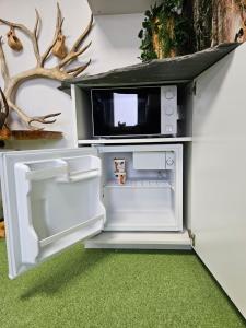于韦斯屈莱ROVIO REST IN FOREST的开放式冰箱,上面配有微波炉
