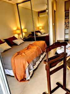 耶尔瓦布埃纳Avenida Aconquija Suites YB的一间卧室配有一张床、镜子和椅子