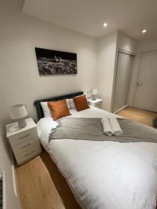 巴塞尔顿Comfortable 2 BR Flat TH542的卧室配有带橙色枕头的大型白色床