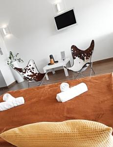 卡尔卡松圣纳泽尔城市阳台公寓的一间卧室配有一张带椅子的床和一台电视。
