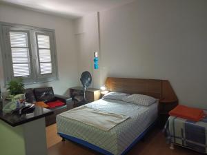 贝洛奥里藏特Apartamento Centro Belo Horizonte的一间卧室配有一张床、一张书桌和一个窗户。