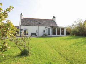 PollacharCorncrake Cottage SU的白色房子,有大草地庭院