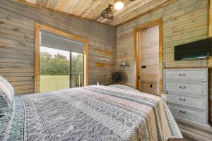 布罗肯鲍Riverfront Broken Bow Cabin with Private Hot Tub!的一间卧室设有一张床和一个大窗户