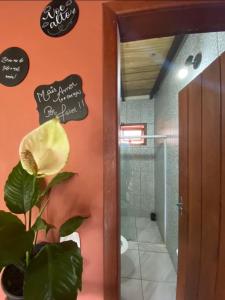 伊塔卡雷FLAT 2 QUARTOS PITUBA - ITACARÉ-Ba的浴室墙上有植物和标志