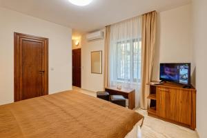 希萨里亚Къща за гости Relax的配有一张床和一台平面电视的酒店客房