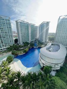 马尼拉Azure Urban Beach Resort by Melrose Avenue的一座建筑,在高楼前设有游泳池