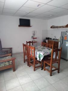 福尔摩沙Alojamiento Temporarios NEA的厨房配有桌椅和冰箱。