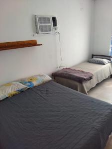 福尔摩沙Alojamiento Temporarios NEA的一间卧室配有两张床和空调。