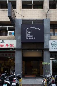 台北疯台北青旅 F​​un Inn Taipei Hostel的停在大楼前的一组摩托车