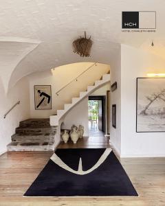 EspollaHotel Canaleta Heras的一间设有楼梯和黑色地毯的客厅