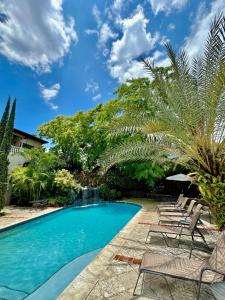 太子港泰雷兹别墅酒店的一个带椅子的游泳池,棕榈树