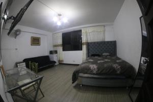 利马Most Central Place in Lima的一间卧室配有一张床和一个沙发
