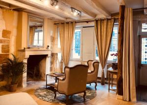 布尔日L’AMANTINE Chambres d’hôtes et gîte的客厅配有两把椅子和壁炉