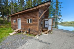 Whale Pass Adventure Cabin的湖畔的小木屋,设有门和楼梯