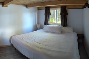 Whale Pass Adventure Cabin的卧室配有一张大白色床和窗户